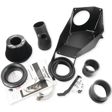 The RamAir intake kit for the Toyota GR Yaris. Pictured are the black heat shield, intake pipe, RamAir air filter, mounting hardware, and installation instructions. The parts are arranged on a white background. The kit optimizes airflow.