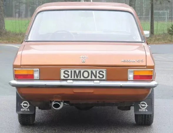 Rear view of a brown Opel Ascona A 1.6, 1.9 with chrome bumper, rear lights and license plate with the lettering Simons. A Simons sports exhaust made of aluminized steel with an oval tailpipe of 70 / 90mm can be seen under the vehicle.