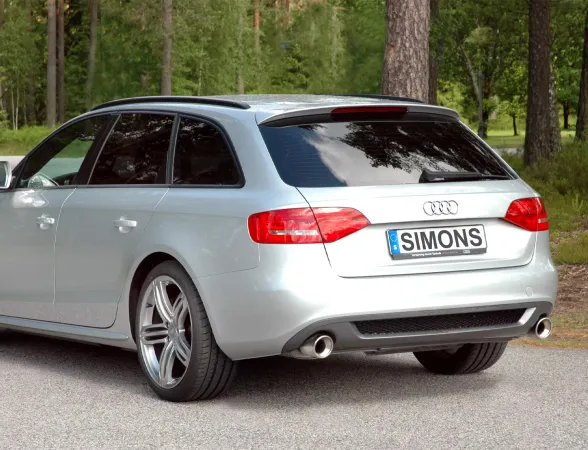 Silver Audi A4 (B8) Avant/station wagon from the rear. The duplex tailpipes (1x100mm) of the Simons sports muffler are visible. The car is standing on asphalt in front of trees. License plate: Simons.