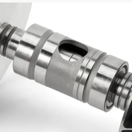 Close-up of a turbocharger upgrade K04-064 Hybrid GEN II component. The silver metal part has a cylindrical shape with circular recesses and an oval hole in the center. It looks robust and precisely manufactured.