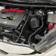 Close-up of the engine bay of a Toyota GR Yaris. The focus is on the installed RamAir Proram intake kit. Visible are the air filter, the heat shield, and the intake manifold. The kit is neatly installed and fits well into the engine bay.
